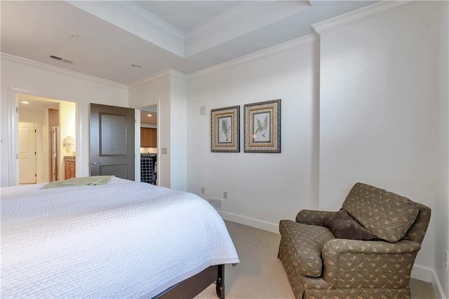 carpeted bedroom featuring ornamental molding and ensuite bath