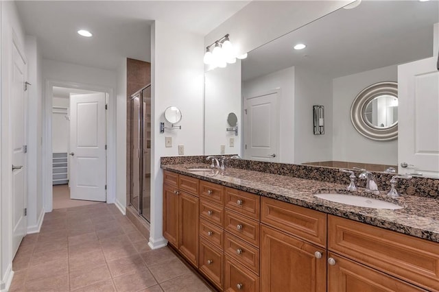 bathroom with a shower with shower door, tile patterned floors, and vanity