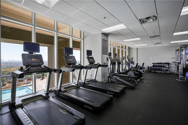 gym with a paneled ceiling and floor to ceiling windows