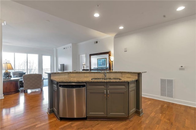 kitchen with dark wood-type flooring, sink, stainless steel dishwasher, and an island with sink