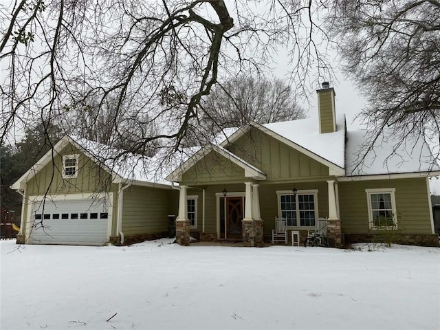 craftsman-style home with covered porch, a chimney, a garage, stone siding, and board and batten siding