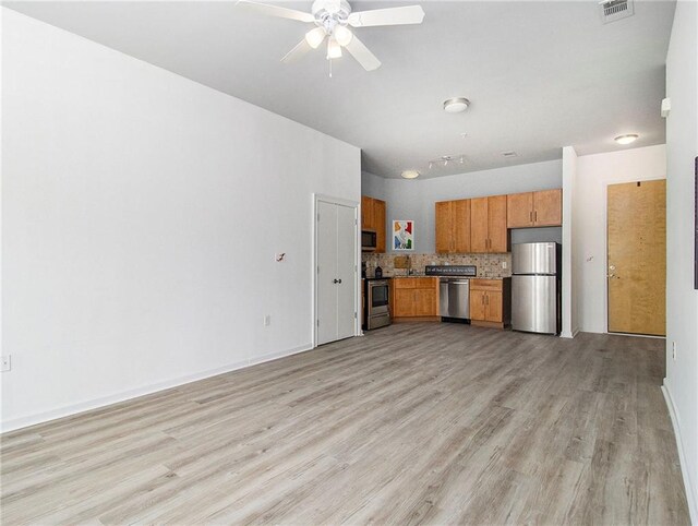 kitchen featuring decorative backsplash, appliances with stainless steel finishes, light hardwood / wood-style flooring, and ceiling fan