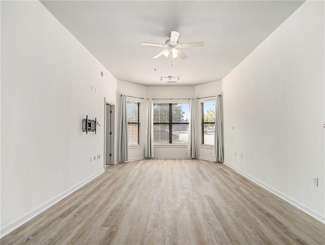 spare room with light wood-type flooring and ceiling fan