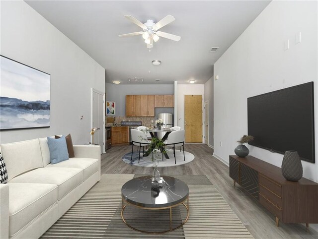 living room with ceiling fan and light hardwood / wood-style flooring