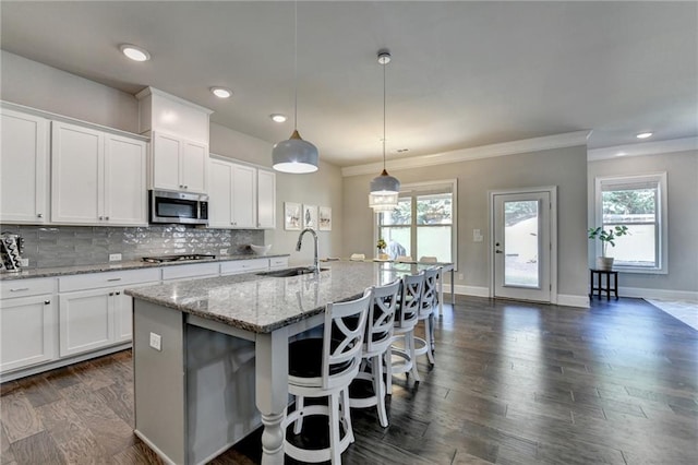 3925 Sierra Knolls Ct, Cumming, GA 30040 - kitchen featuring appliances with stainless steel finishes, a sink, a center island with sink, tasteful backsplash, and white cabinetry