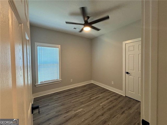 spare room with dark hardwood / wood-style floors and ceiling fan