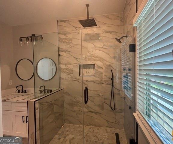 bathroom with vanity, a healthy amount of sunlight, and an enclosed shower