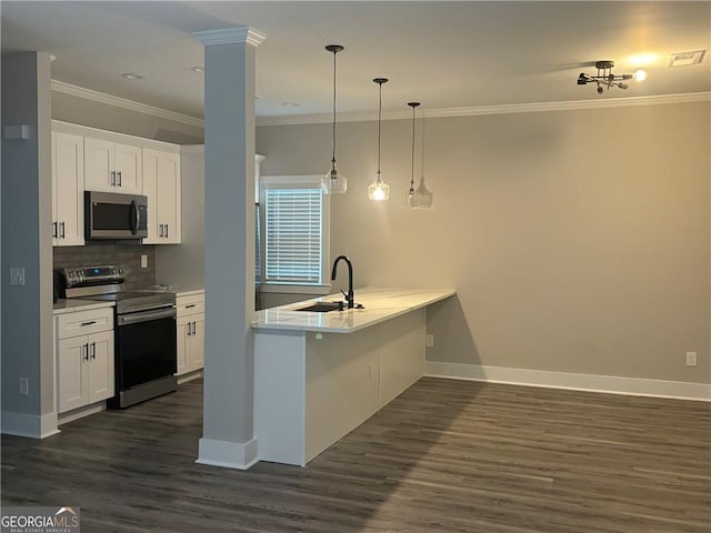 kitchen featuring kitchen peninsula, appliances with stainless steel finishes, sink, pendant lighting, and white cabinetry