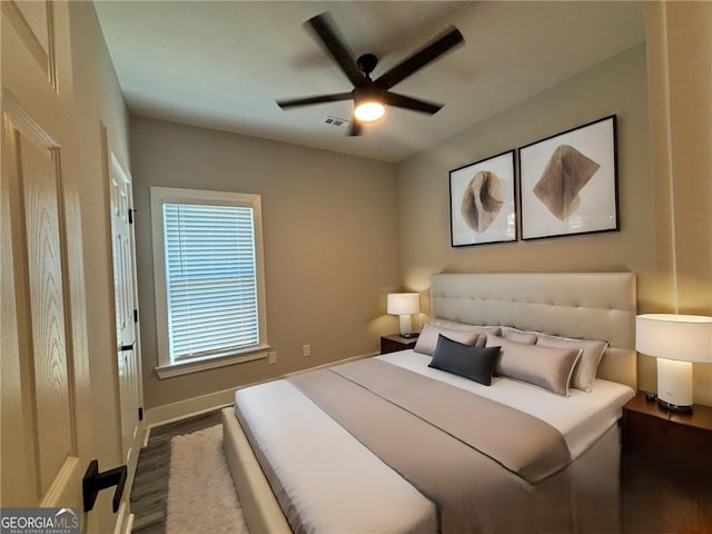 bedroom with ceiling fan and dark wood-type flooring