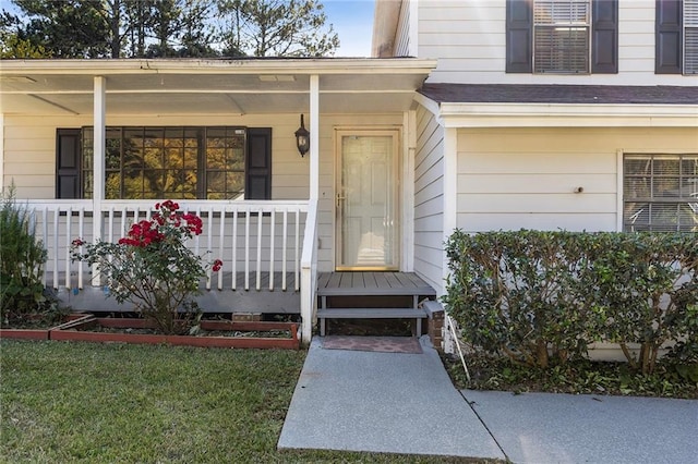 property entrance featuring a porch and a yard