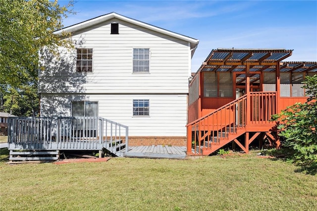 rear view of property with a deck and a lawn