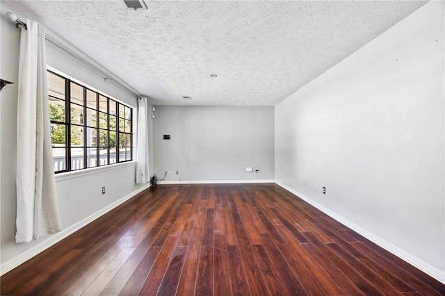 empty room featuring dark wood-type flooring and a textured ceiling