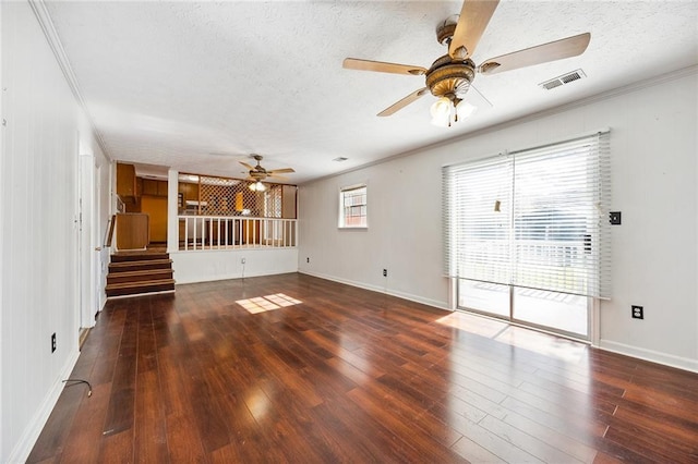 unfurnished living room featuring crown molding, dark hardwood / wood-style floors, and a textured ceiling