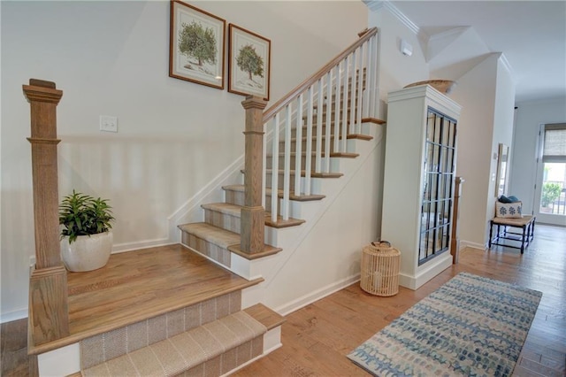 stairway featuring wood finished floors and baseboards