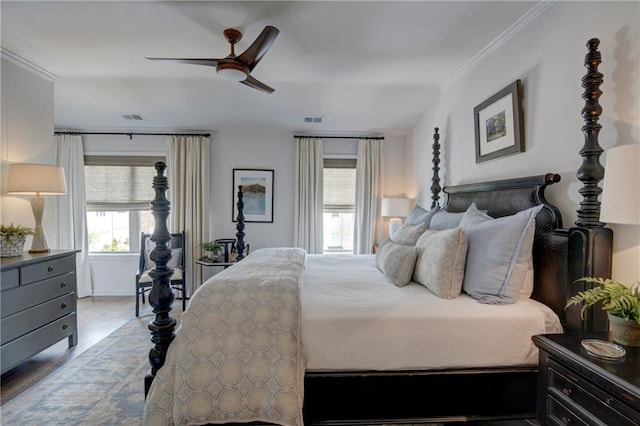 bedroom with wood finished floors, ornamental molding, and ceiling fan