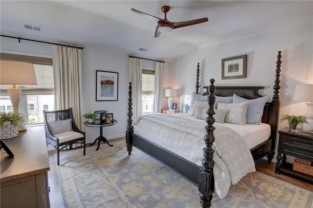 bedroom with wood finished floors, ornamental molding, ceiling fan, and baseboards