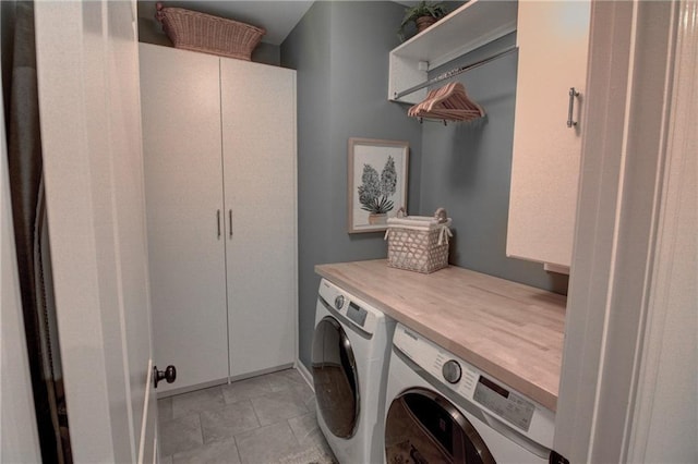laundry room featuring washer and clothes dryer, cabinet space, and light tile patterned floors