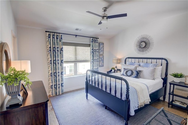 bedroom featuring wood finished floors, baseboards, and ceiling fan