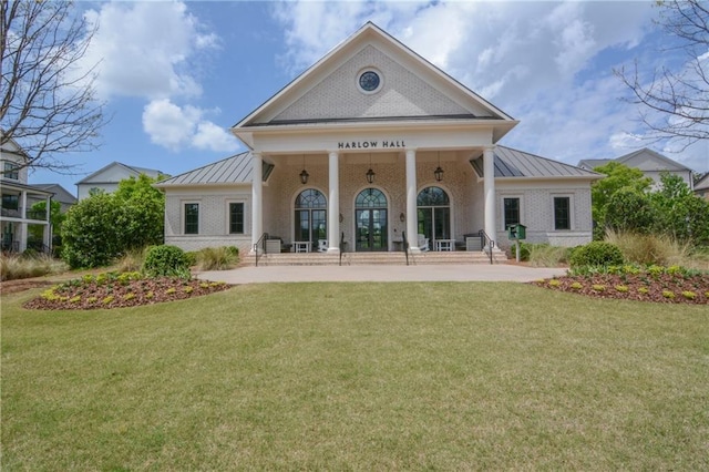 rear view of house with a standing seam roof, a yard, and metal roof