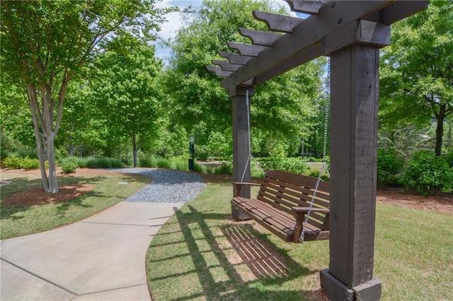 view of home's community featuring a lawn, a pergola, and view of scattered trees