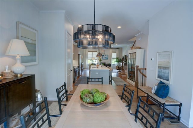 dining space featuring baseboards, recessed lighting, wood finished floors, and crown molding