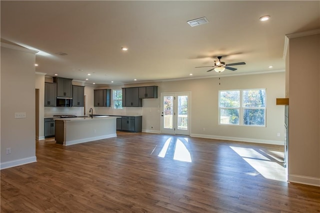 unfurnished living room featuring crown molding, dark wood-type flooring, and ceiling fan