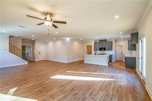 unfurnished living room featuring ceiling fan, ornamental molding, and light hardwood / wood-style flooring