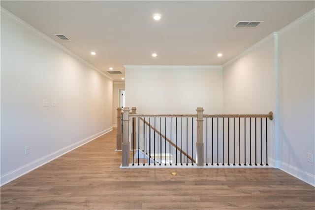 hallway featuring ornamental molding and light hardwood / wood-style floors