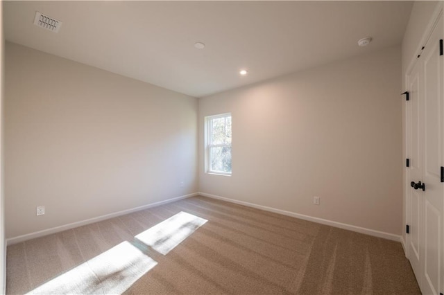 unfurnished room featuring light colored carpet