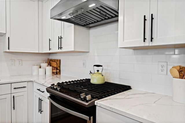 kitchen featuring white cabinetry, custom exhaust hood, black gas range oven, and backsplash