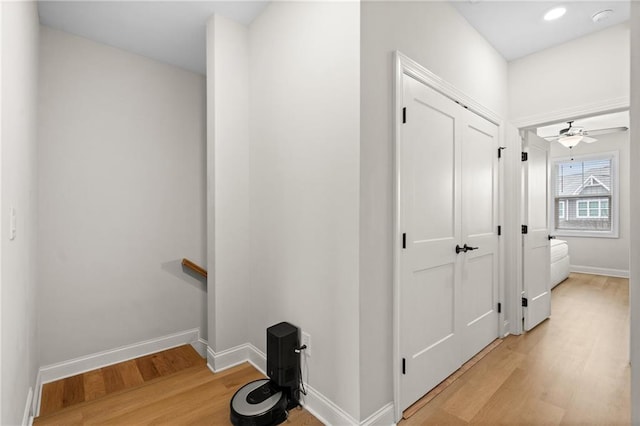 hallway featuring recessed lighting, an upstairs landing, baseboards, and light wood finished floors