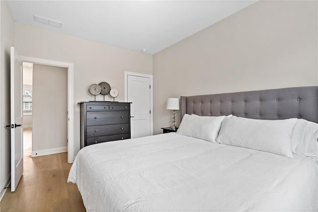 bedroom featuring visible vents, baseboards, and light wood-style floors