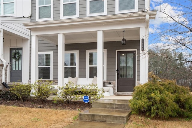 entrance to property with board and batten siding and a porch