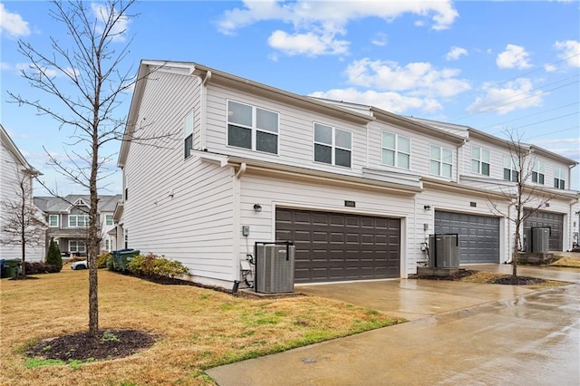 multi unit property featuring central AC unit, an attached garage, and a front lawn