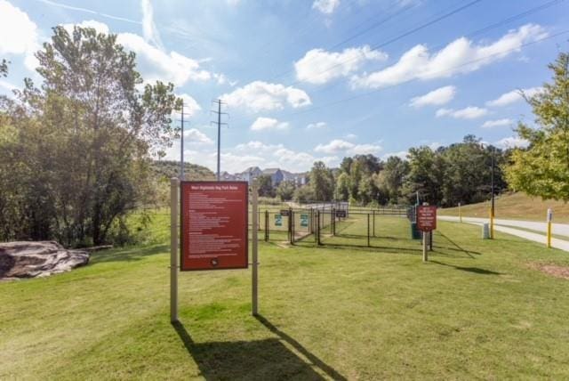 view of home's community featuring a lawn and fence