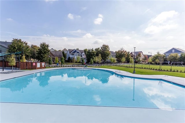 view of pool with a fenced in pool, fence, a lawn, and a residential view