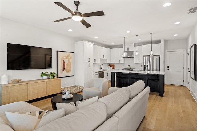 living area featuring recessed lighting, light wood-type flooring, visible vents, and a ceiling fan