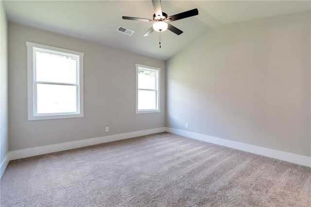 unfurnished bedroom featuring lofted ceiling, light colored carpet, ceiling fan, and ensuite bath