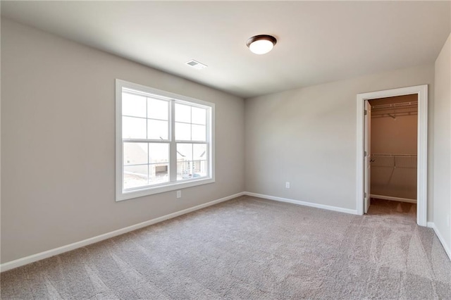 329 Willow Cv, Canton, GA 30114 - unfurnished bedroom featuring visible vents, baseboards, a closet, carpet, and a walk in closet