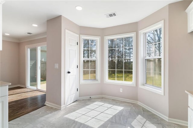 unfurnished dining area featuring visible vents, baseboards, and plenty of natural light