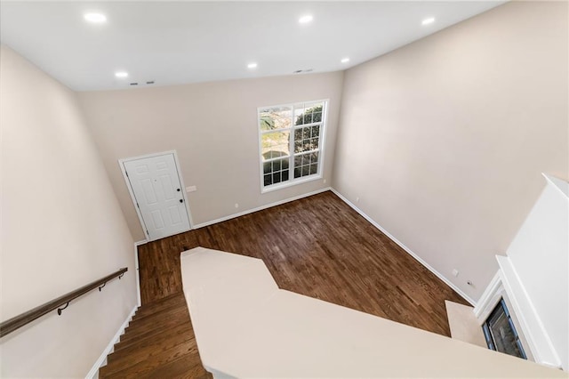 stairway featuring recessed lighting, wood finished floors, and baseboards