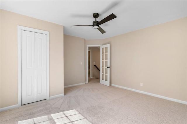 unfurnished bedroom with carpet, french doors, a closet, and baseboards