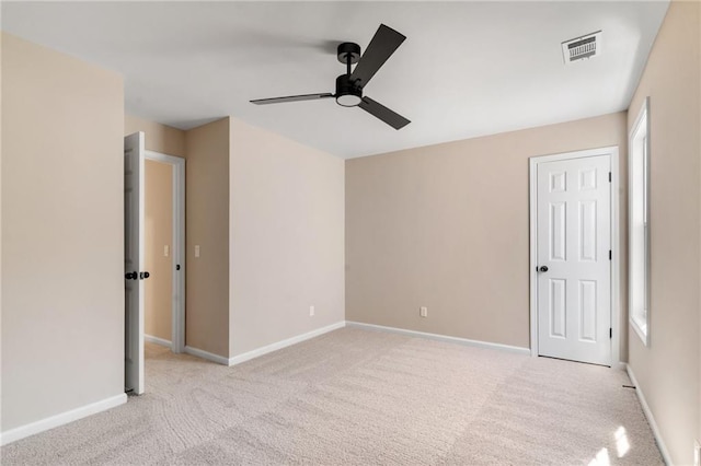 unfurnished bedroom featuring visible vents, multiple windows, carpet, baseboards, and ceiling fan