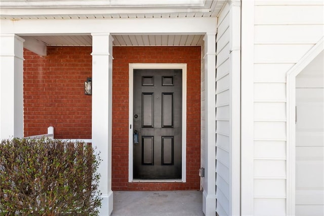 doorway to property with brick siding