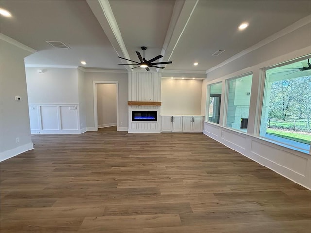 unfurnished living room with ceiling fan, a large fireplace, wood-type flooring, and ornamental molding