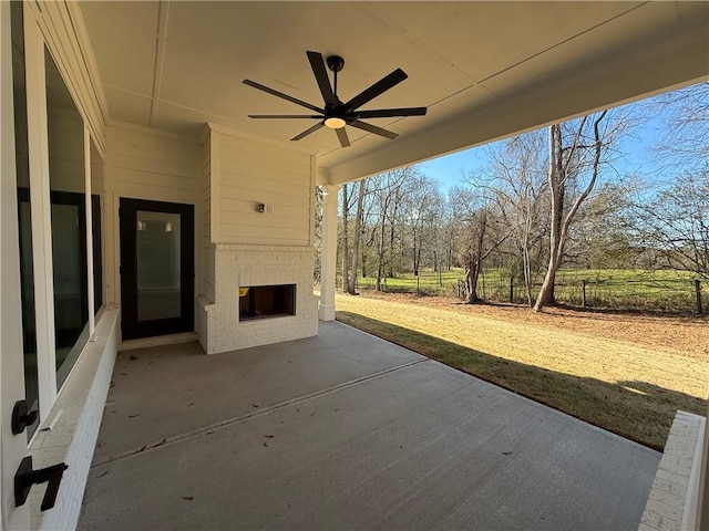 view of patio with ceiling fan and an outdoor brick fireplace