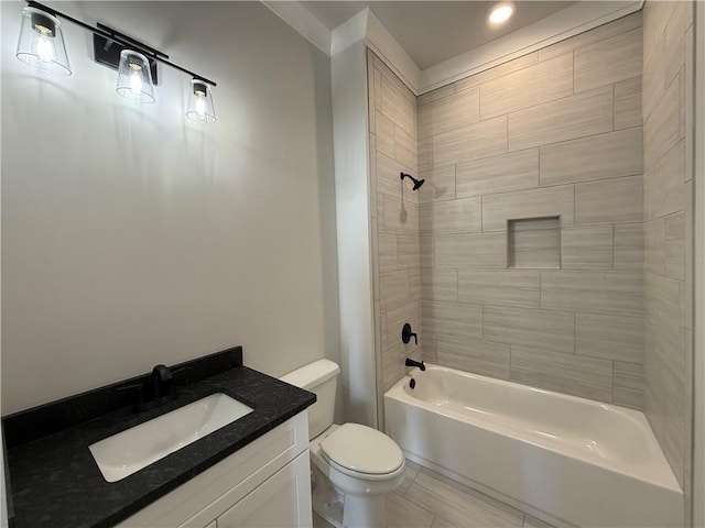 full bathroom featuring tile patterned floors, tiled shower / bath combo, toilet, and vanity