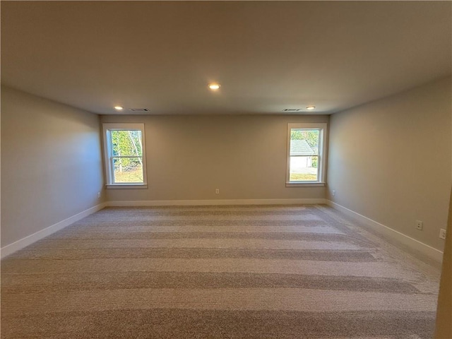 spare room with plenty of natural light and light colored carpet