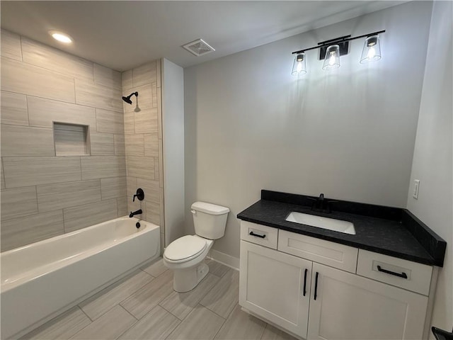 full bathroom with vanity, toilet, and tiled shower / bath