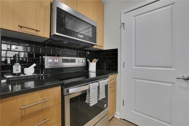 kitchen with stainless steel appliances, light hardwood / wood-style floors, and tasteful backsplash